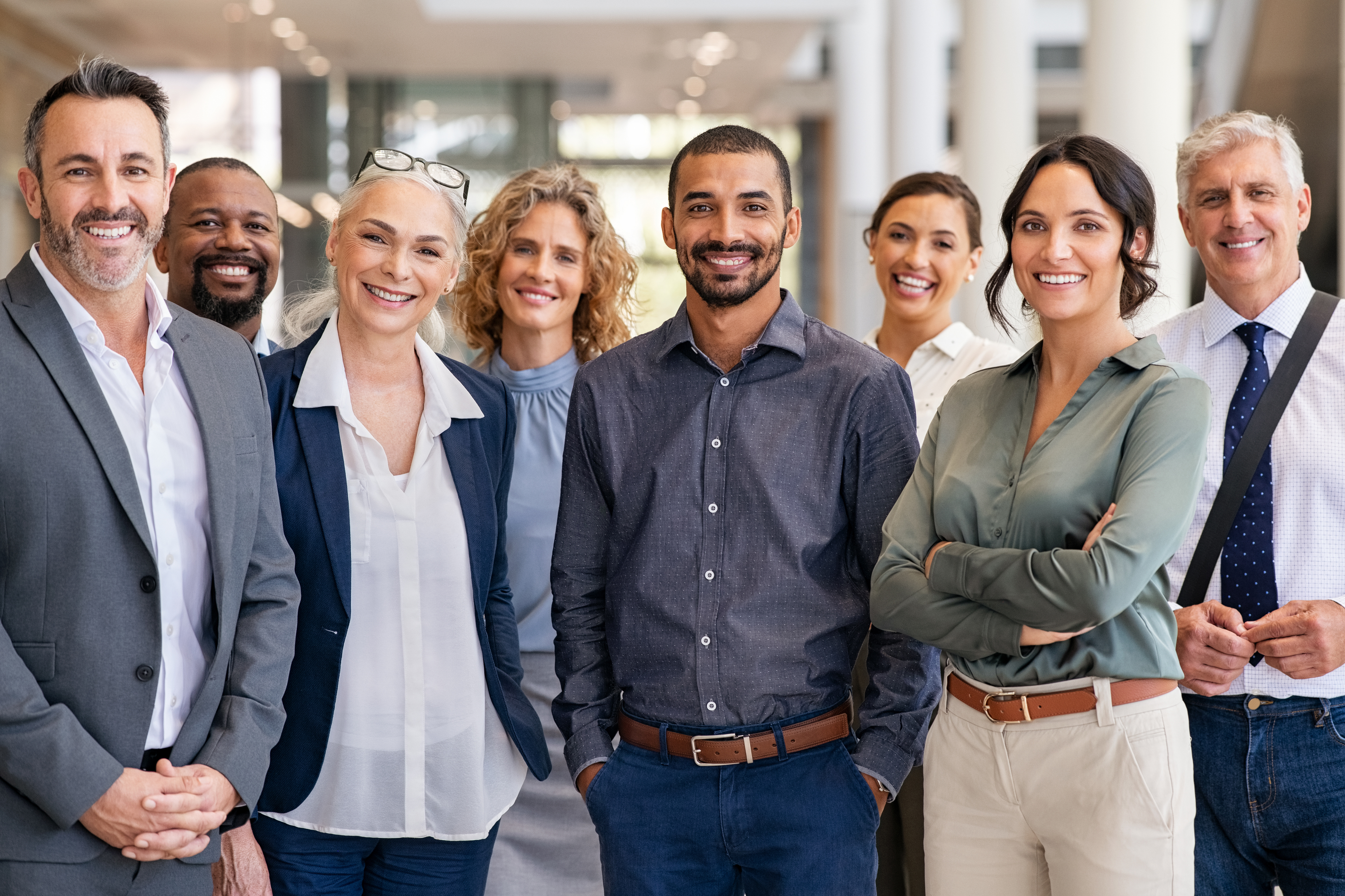 Partner and Engagements 26 Portrait of successful group of business people at modern office looking at camera. Portrait of happy businessmen and satisfied businesswomen standing as a team. Multiethnic group of people smiling and looking at camera.