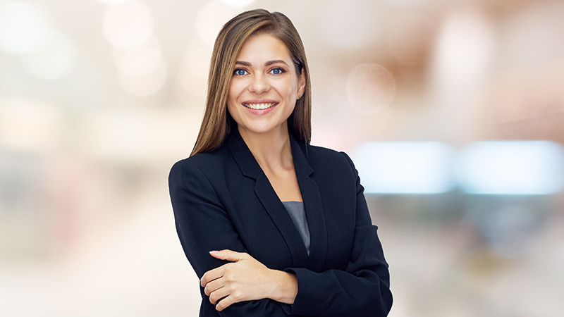 Smiling woman standing with crossed arms. Businesswoman isolated professional portrait.